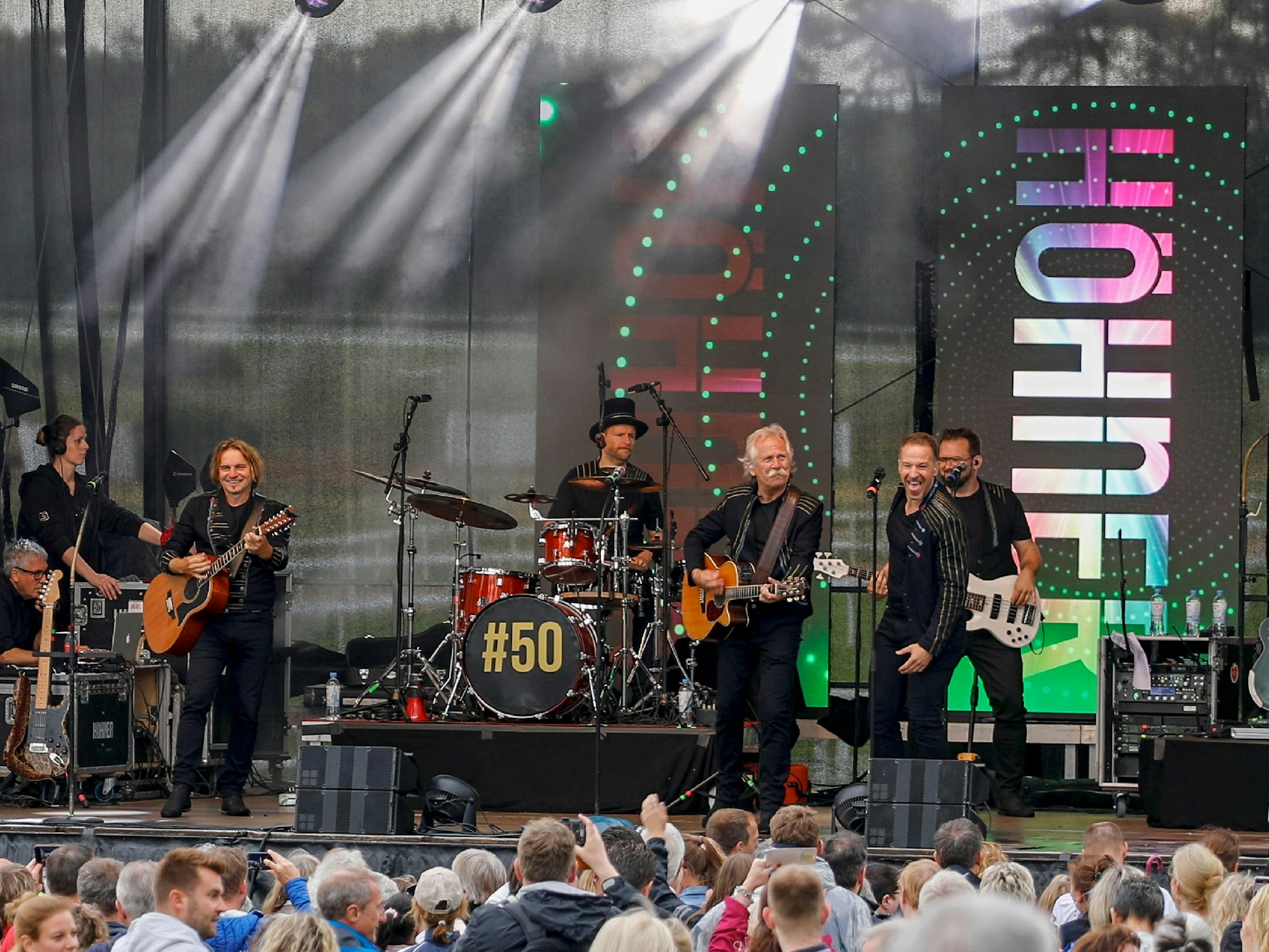 Die Höhner geben auf einer Bühne vor vielen Fans ein Konzert.