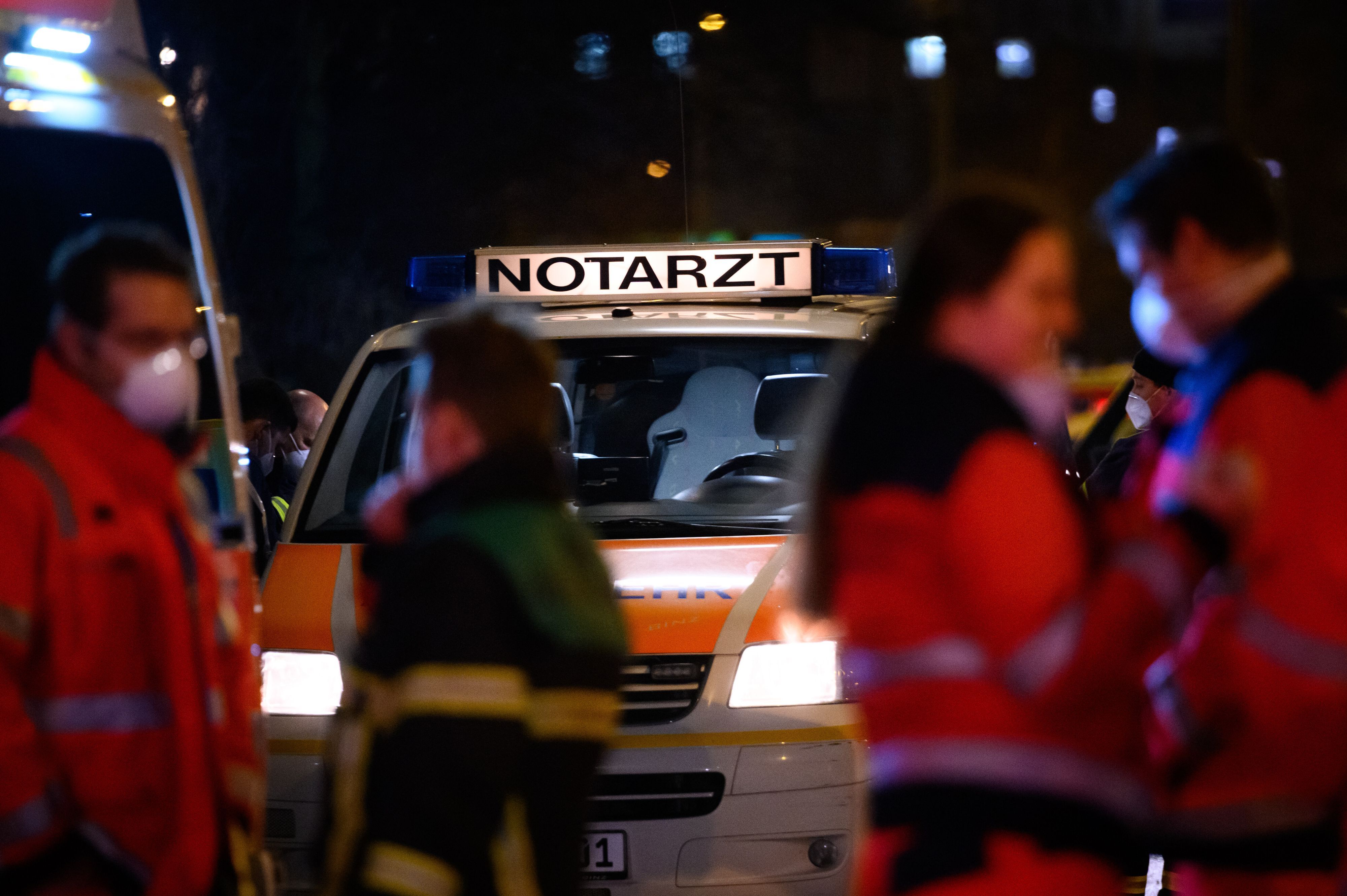 „Notarzt“ steht auf einem Fahrzeug der Feuerwehr, vor dem sich mehrere Einsatz- und Rettungskräfte besprechen.