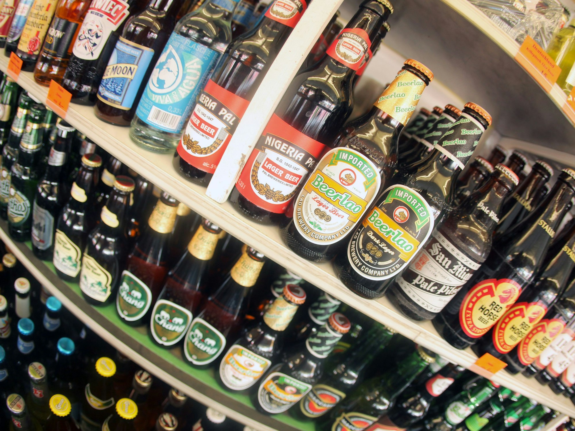 Verschiedene internationale Biersorten mit individuell gestalteten Flaschen-Etiketten werden auf einer Bierbörse angeboten.