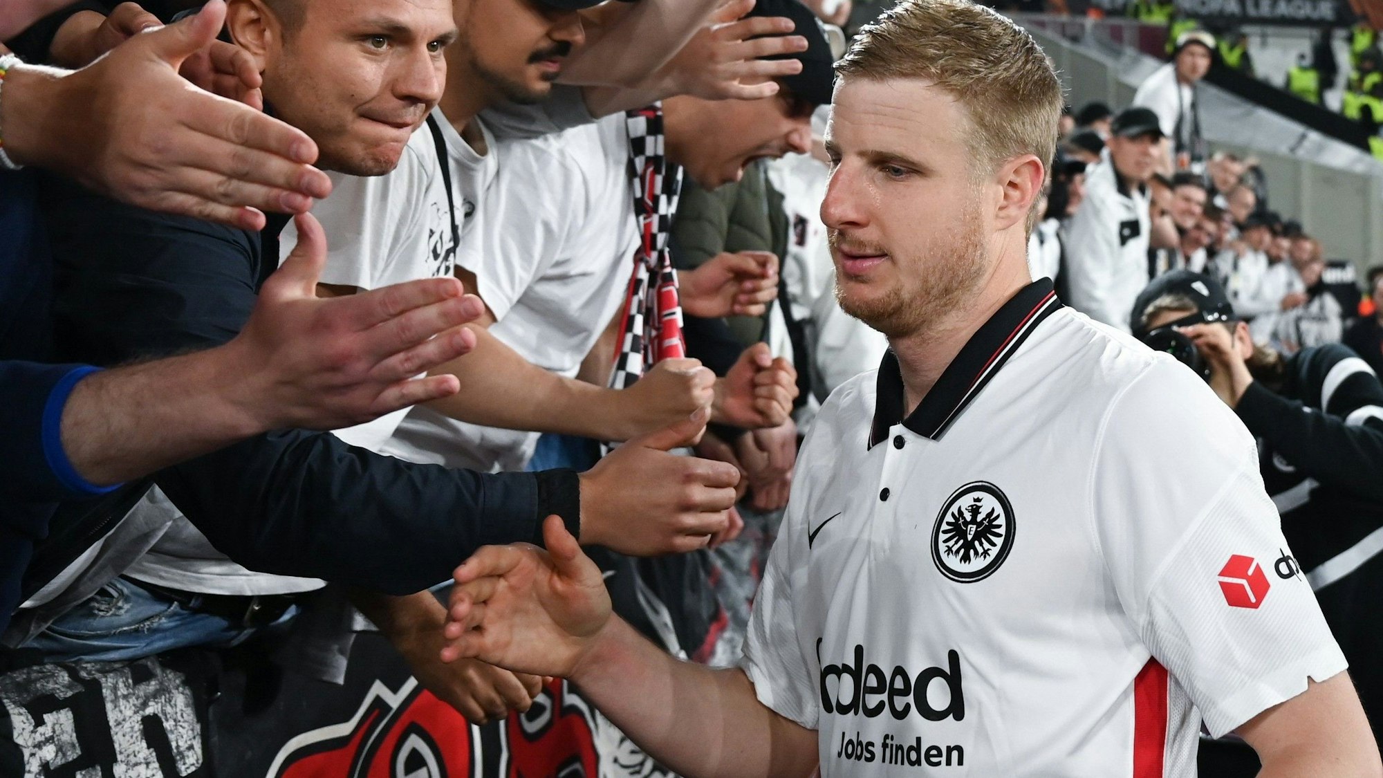 Martin Hinteregger (r) wird nach einem Spiel von Eintracht Frankfurt von den mitgereisten Fans gefeiert. Hinteregger kündigte jetzt sein Karriereende an.