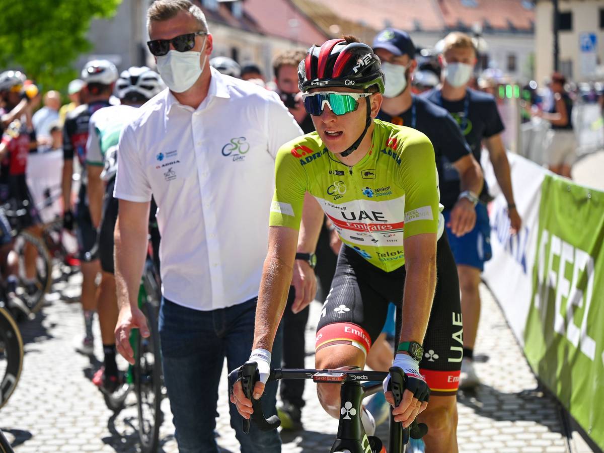 Radprofi Tadej Pogacar wird im Ziel von einem Teambetreuer mit Maske in Empfang genommen.