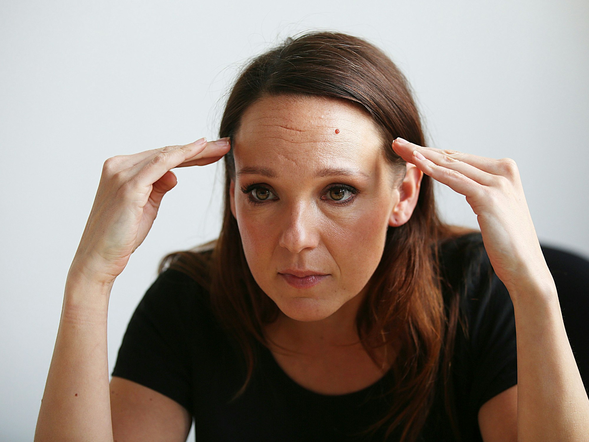 Die Komikerin Carolin Kebekus fasst sich während eines Interviews am 26. April 2018 an den Kopf.