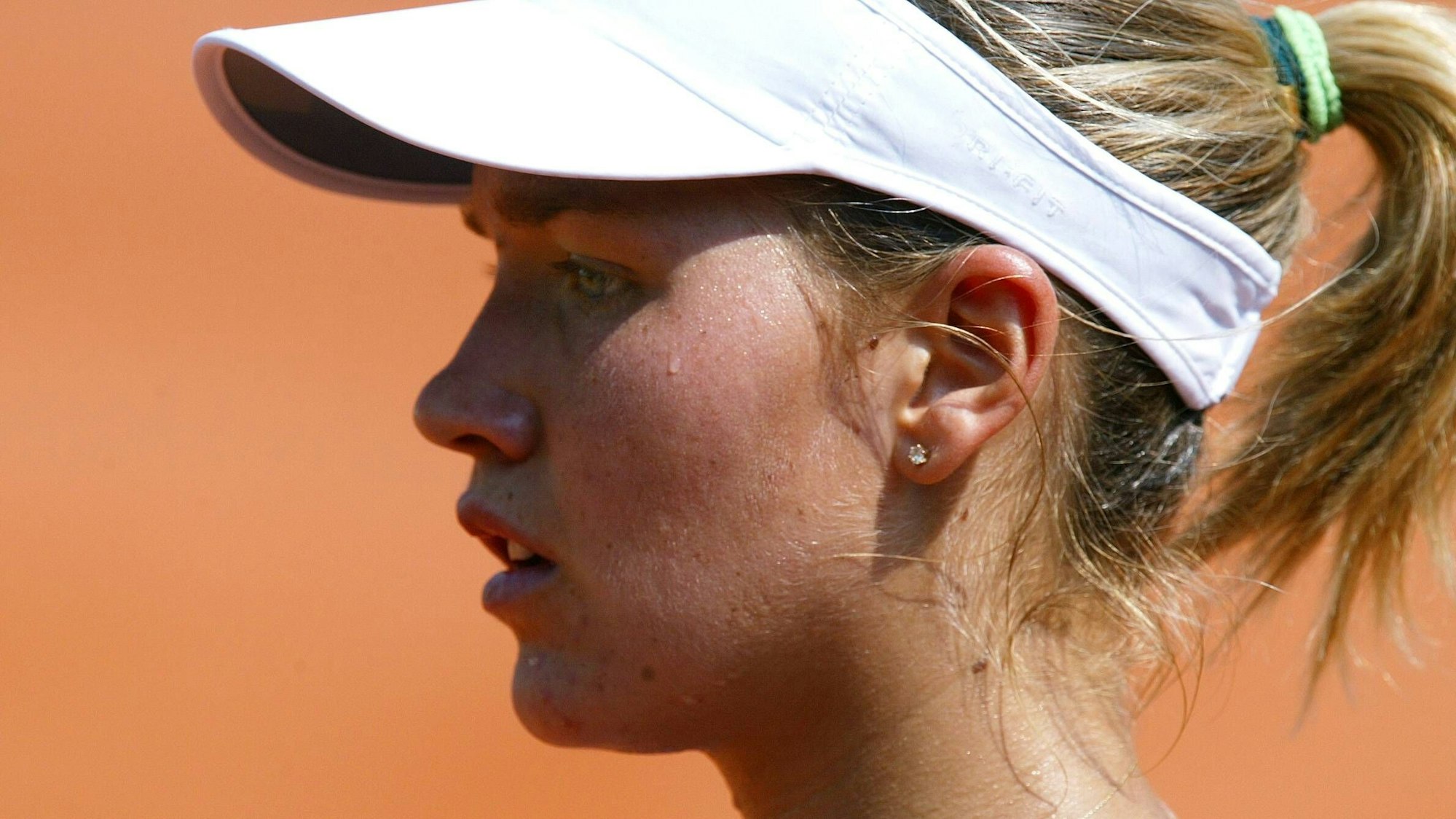 Ashley Harkleroad (USA) steht mit Schirmmützeauf dem Tennisplatz.