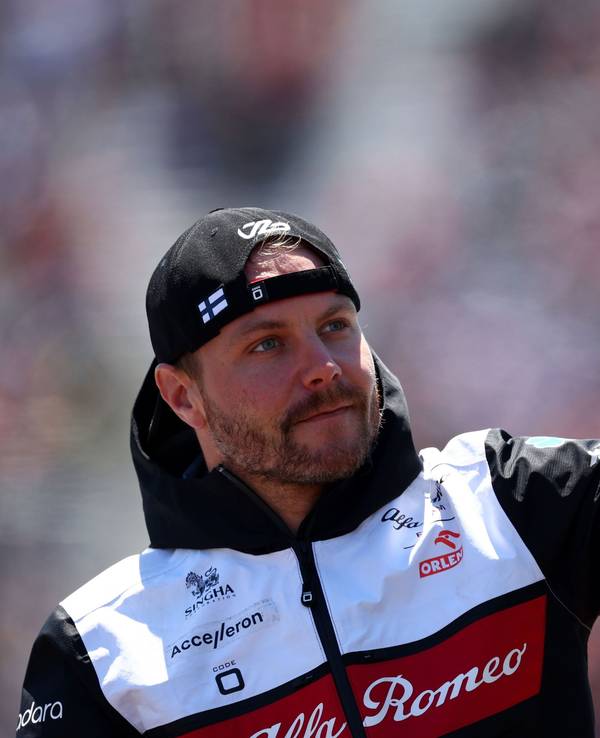 Valtteri Bottas hat eine Kappe verkehrt herum auf und winkt.