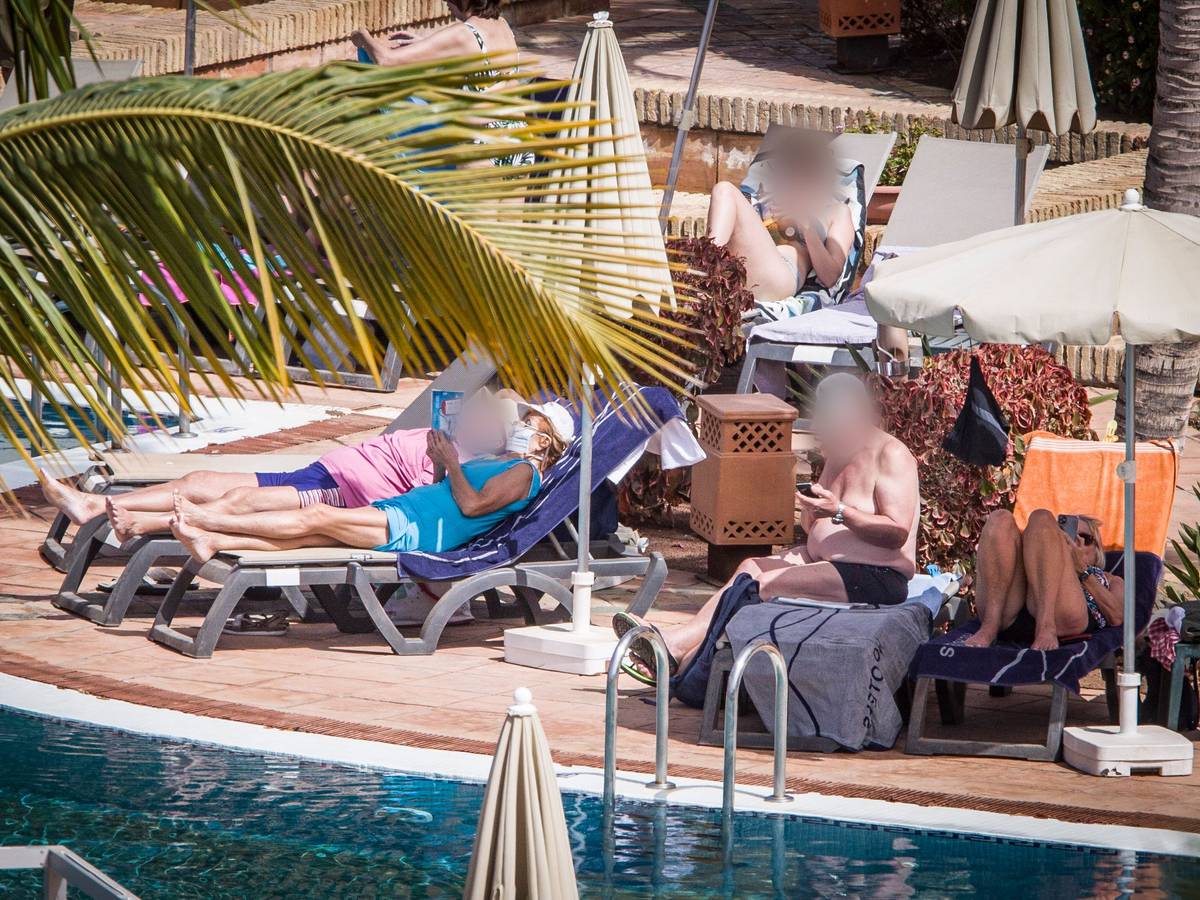 Hotelgäste sonnen sich am Pool. Das wegen Coronavirus-Fällen unter Quarantäne gestellte Hotel auf Teneriffa ist weiterhin durch die Polizei abgeriegelt.