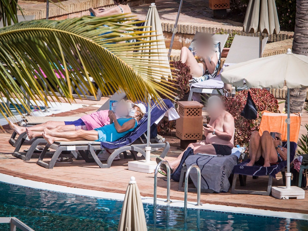 Hotelgäste sonnen sich am Pool. Das wegen Coronavirus-Fällen unter Quarantäne gestellte Hotel auf Teneriffa ist weiterhin durch die Polizei abgeriegelt.