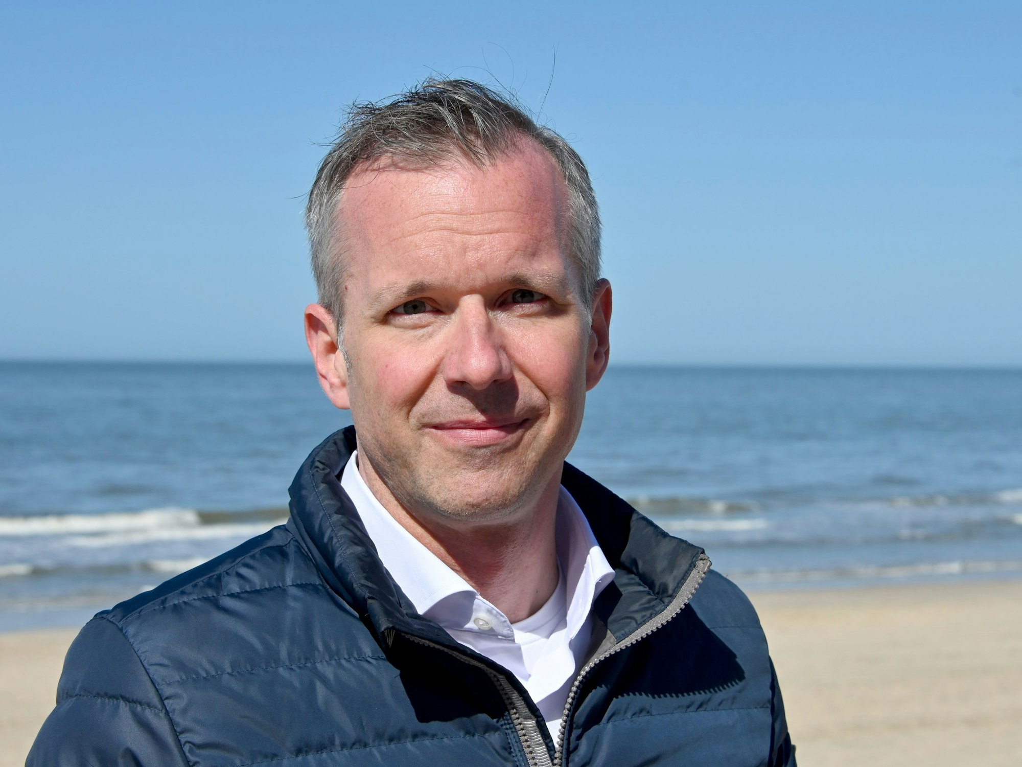 Nikolas Häckel, Bürgermeister der Gemeinde Sylt, steht an der Promenade.