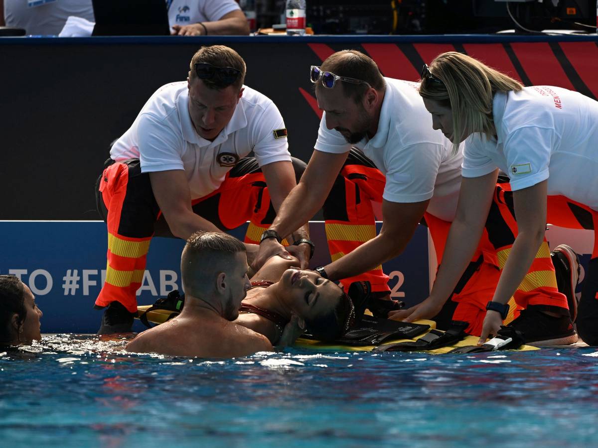 Anita Alvarez wird nach ihrer Rettung im Wasser bei der Schwimm-WM in Budapest von Sanitäterinnen und Sanitätern am Beckenrand in Empfang genommen.