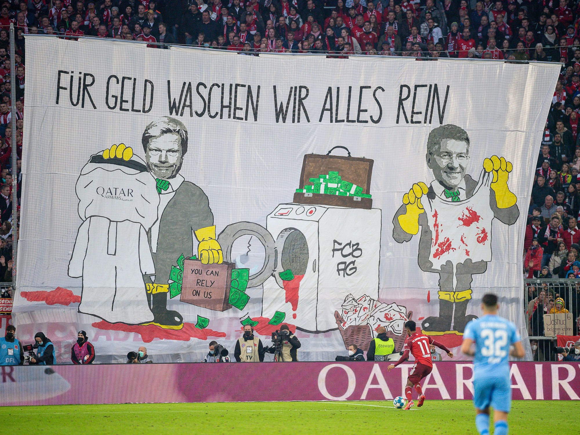 Mit einem Transparent „Für Geld waschen wir alles rein“ protestieren Münchner Fans in der Allianz Arena.