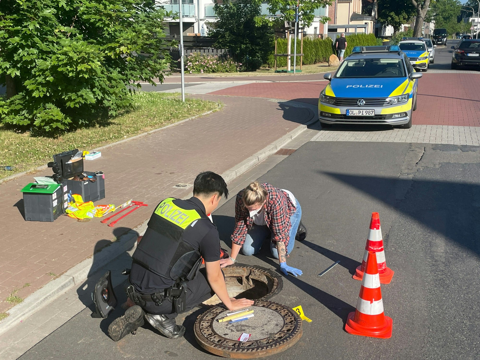 Polizeikräfte untersuchen einen Gully. Ein seit acht Tagen vermisster Achtjähriger aus Oldenburg ist lebend in einem Gully gefunden worden. Der geistig behinderte Junge namens Joe war am 17. Juni 2022 zuletzt gesehen worden.