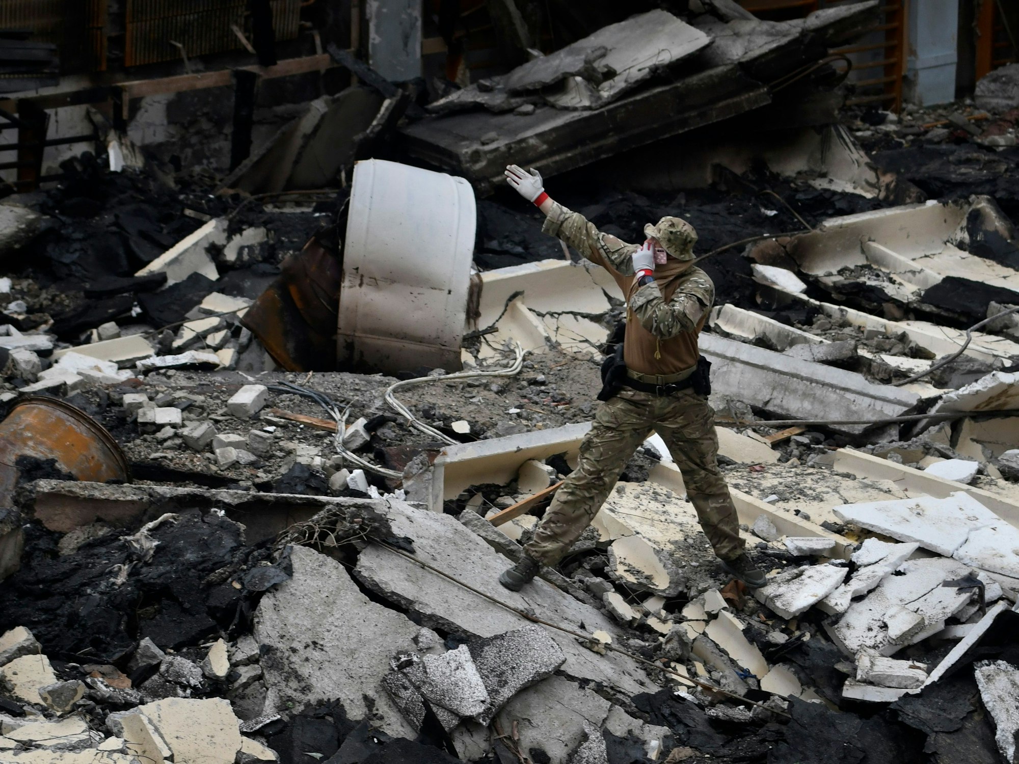 Ein Mann steht am 24. Juni 2022 auf Trümmern in einem durch russischen Beschuss zerstörten Sportkomplex der Polytechnischen Hochschule von Kyjiw.