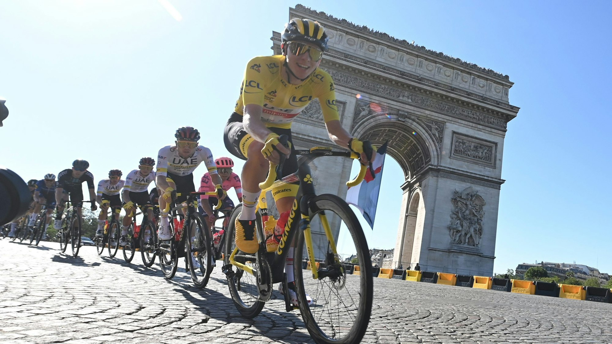 Der Slowene Tadej Pogacar vom UAE Team Emirates im Gelben Trikot des Gesamtführenden passiert den Arc De Triomphe.