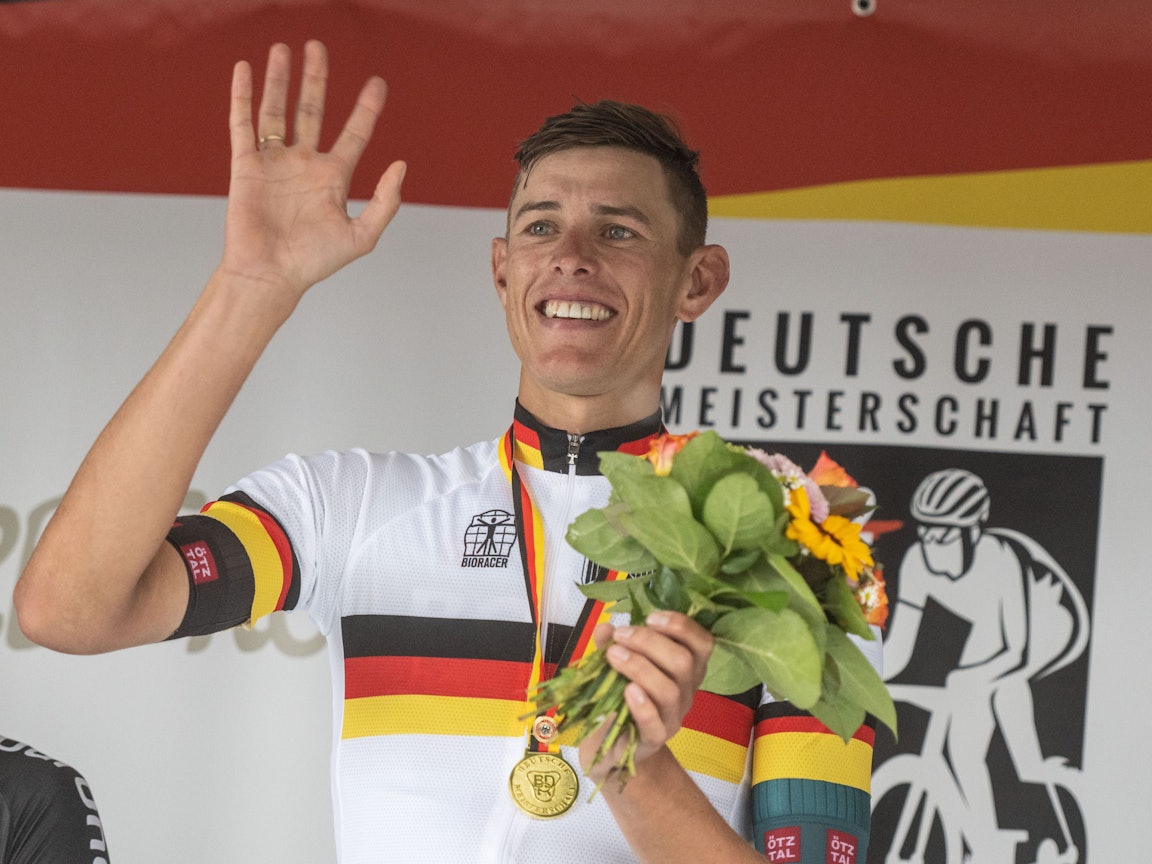 Nils Politt vom Team Bora - hansgrohe winkt nach seinem Sieg bei der Siegerehrung.