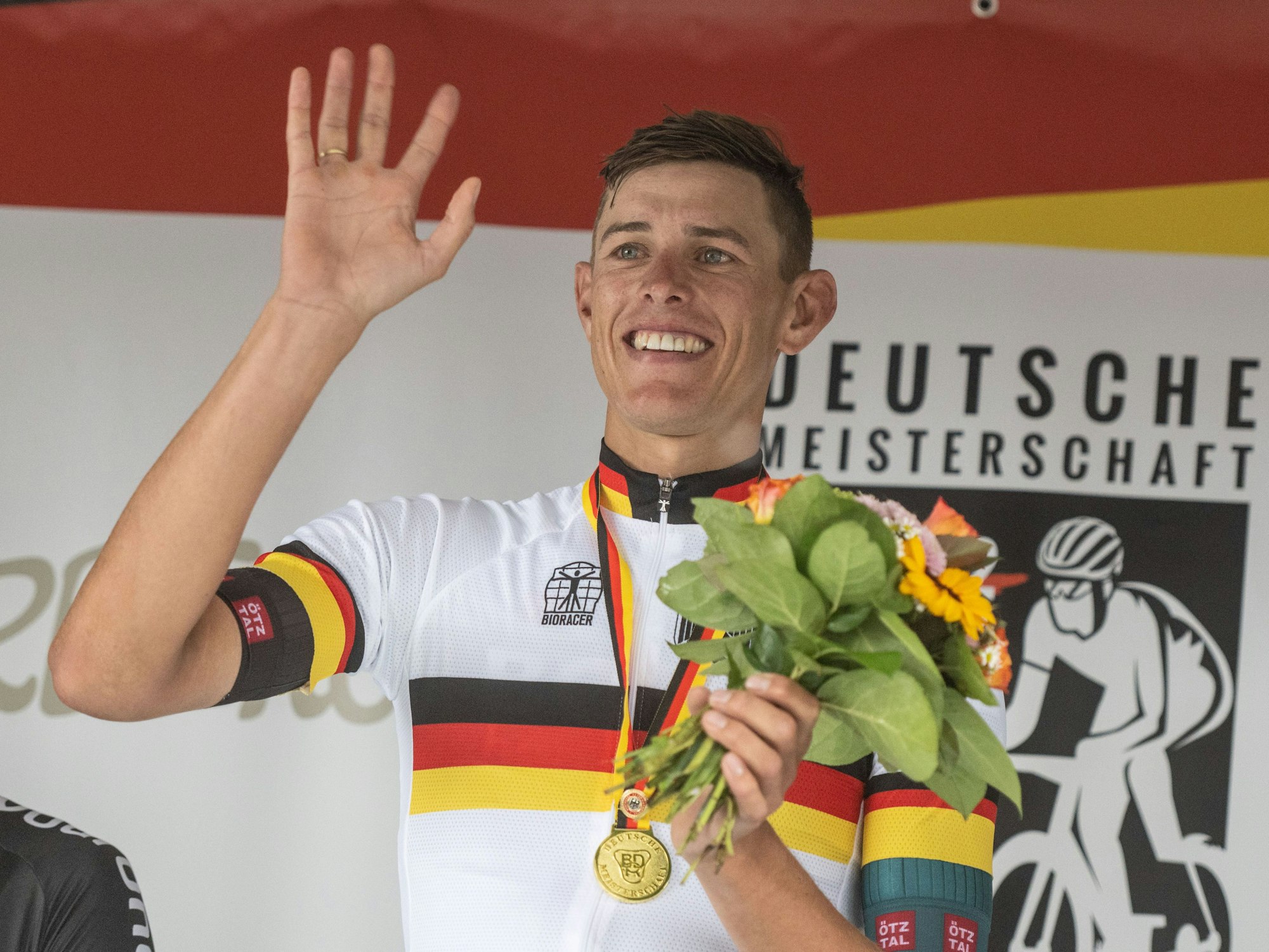 Nils Politt vom Team Bora - hansgrohe winkt nach seinem Sieg bei der Siegerehrung.