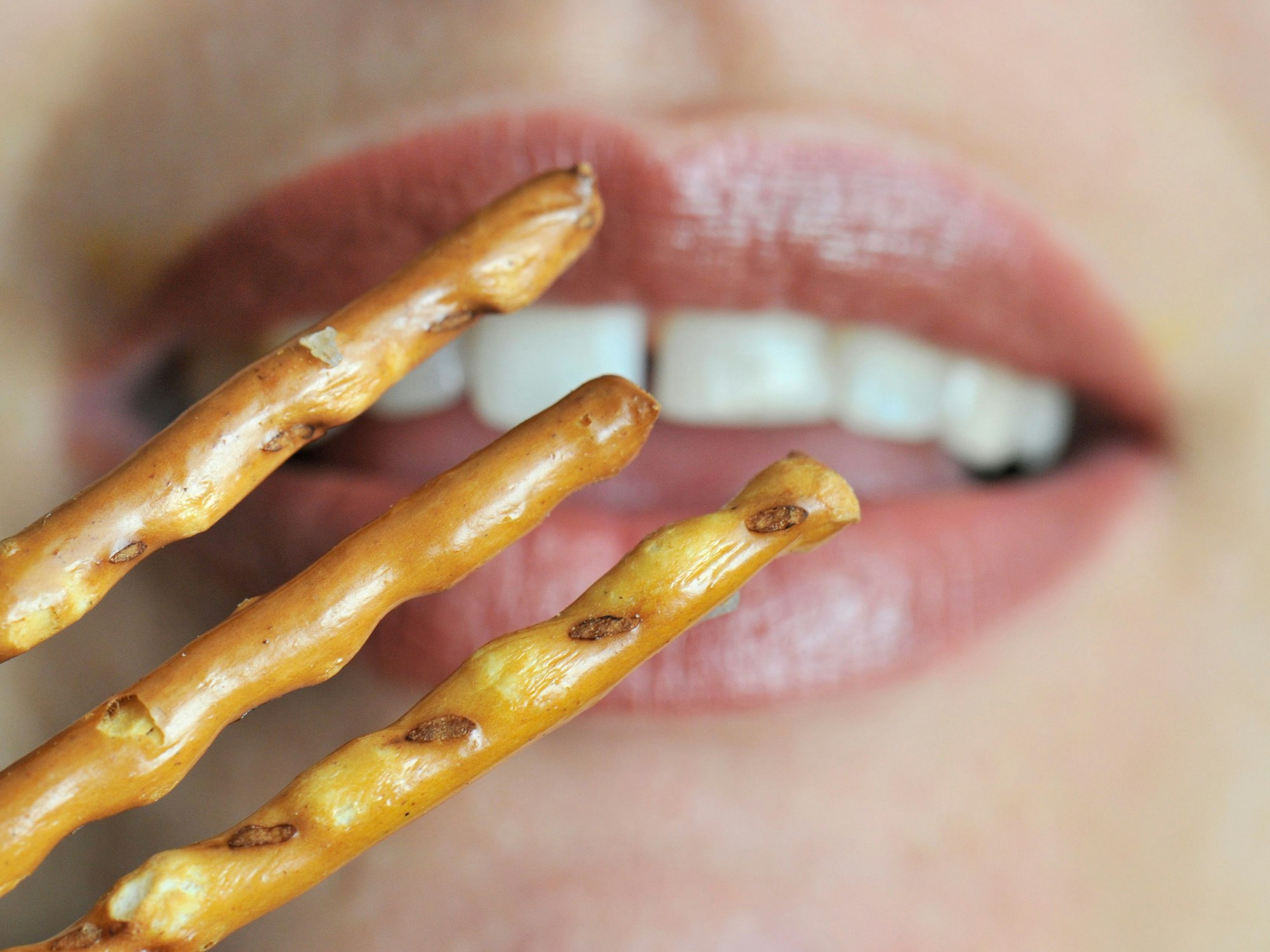 Kaufland hat Party-Snacks angepriesen und eine Diskussion losgetreten. Unser Foto zeigt eine Frau, die Salzstangen zum Mund führt.