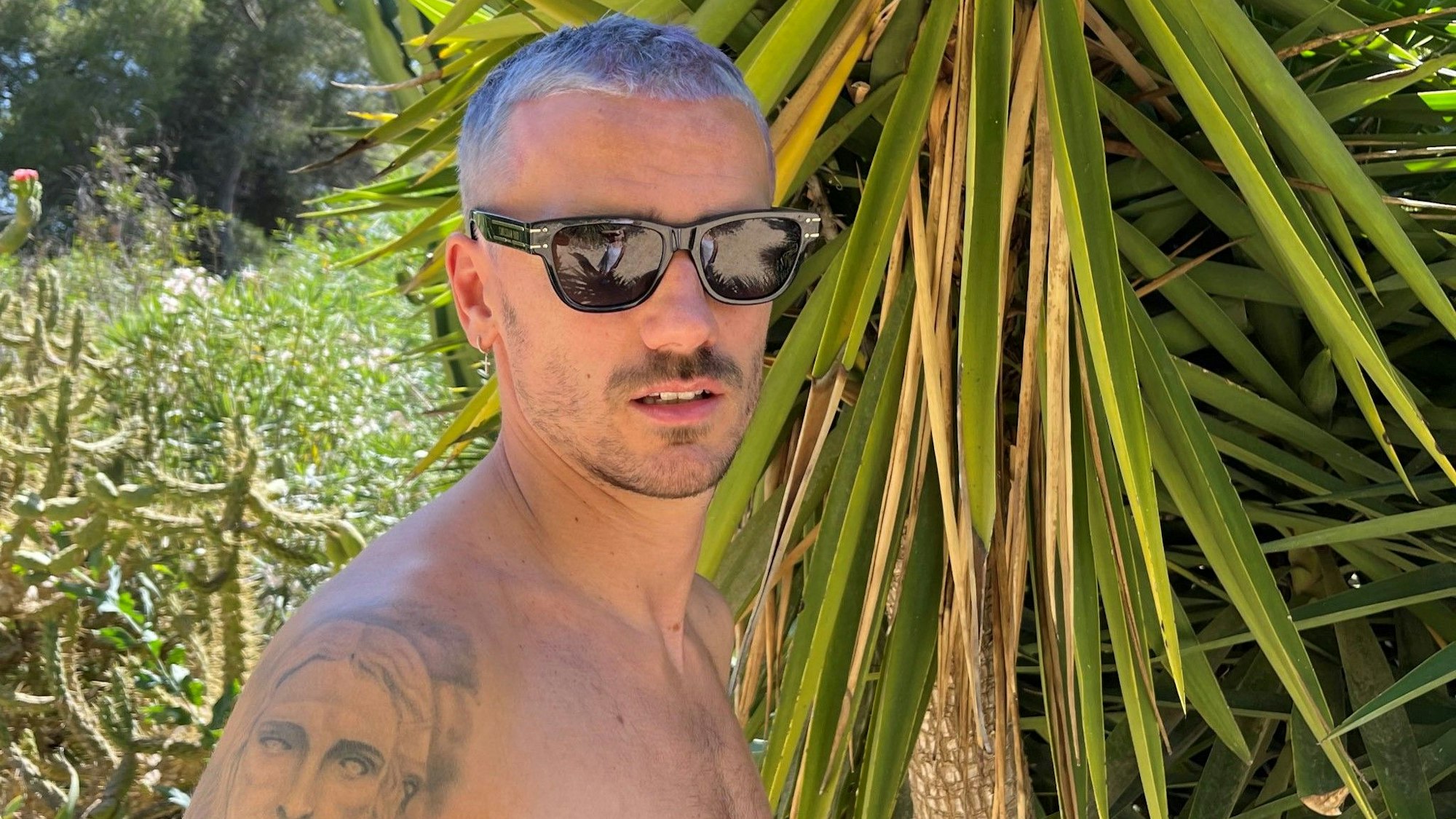 Antoine Griezmann mit neuer Frisur auf einem sonnigen Schnappschuss mit Sonnenbrille.