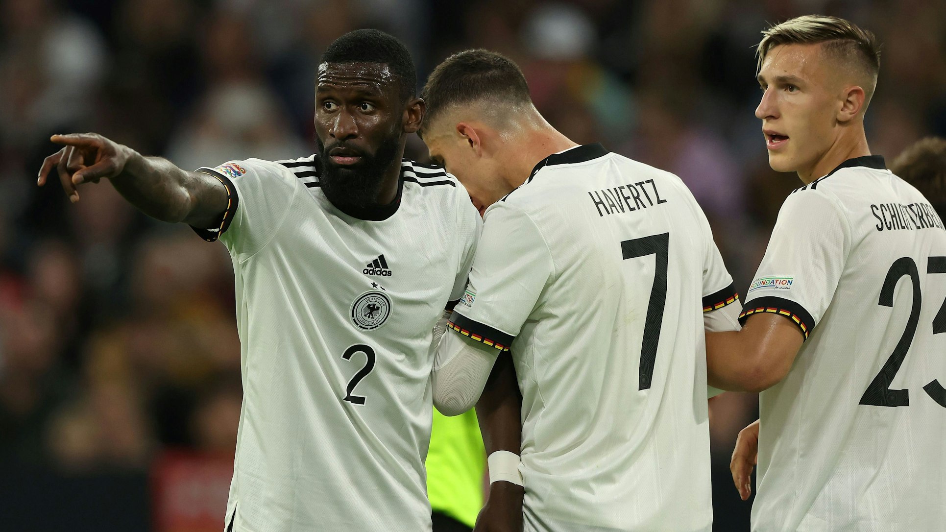 Antonio Rüdiger spricht beim Stellen der Mauer mit Kai Havertz und Nico Schlotterbeck