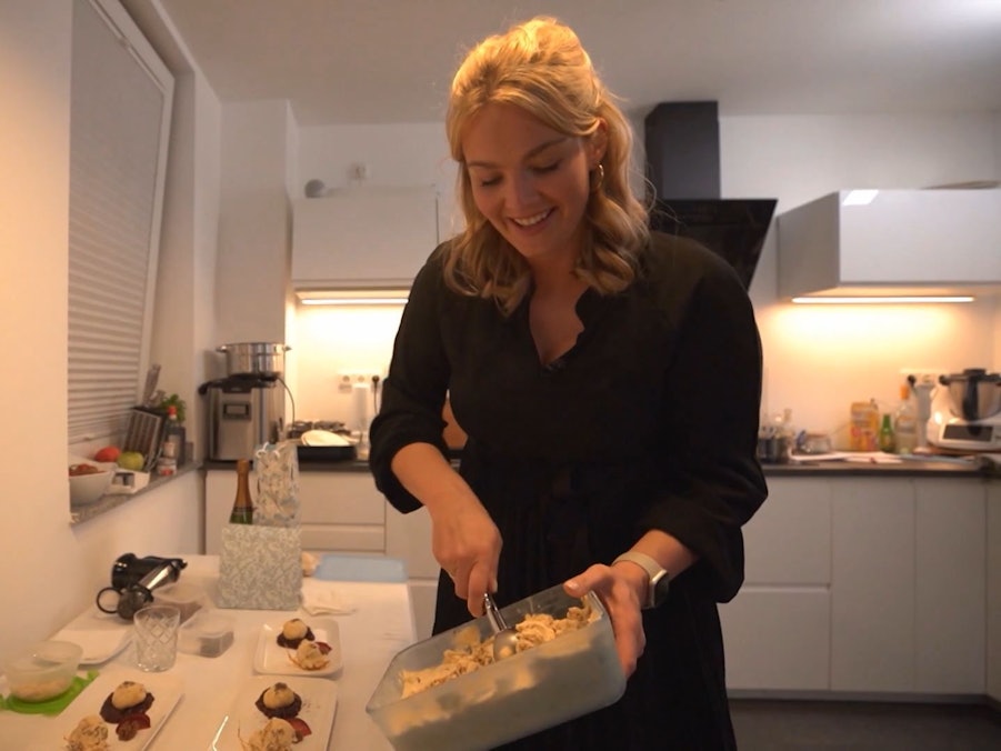 Gastgeberin Natalie steht am ersten Tag von Das perfekte Dinner in Düsseldorf (TV-Ausstrahlung: 27. Juni 2022) in ihrer Küche und bereitet Essen zu.