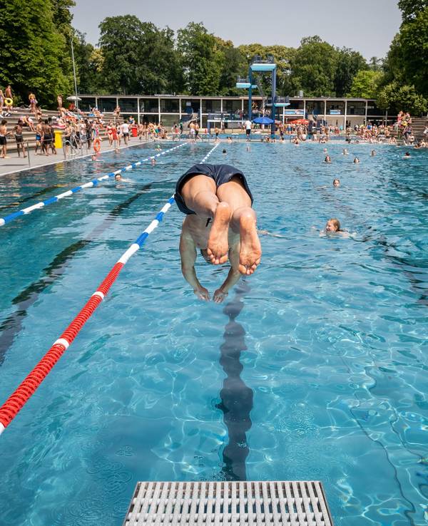 Ein junger Mann macht einen Kopfsprung ins Wasser.