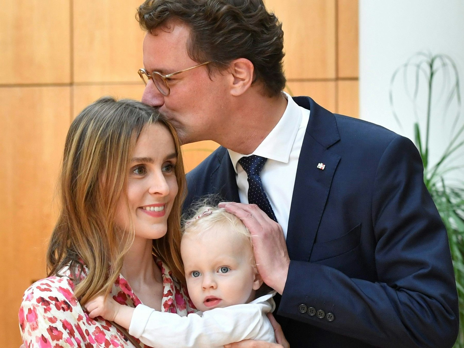 Hendrik Wüst küsst seine Ehefrau Katharina und Tochter Philippa im Landtag.