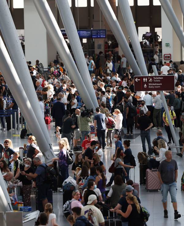 Passagiere stehen am 25. Juni 2022 im Flughafen Düsseldorf und warten auf ihre Abfertigungen.