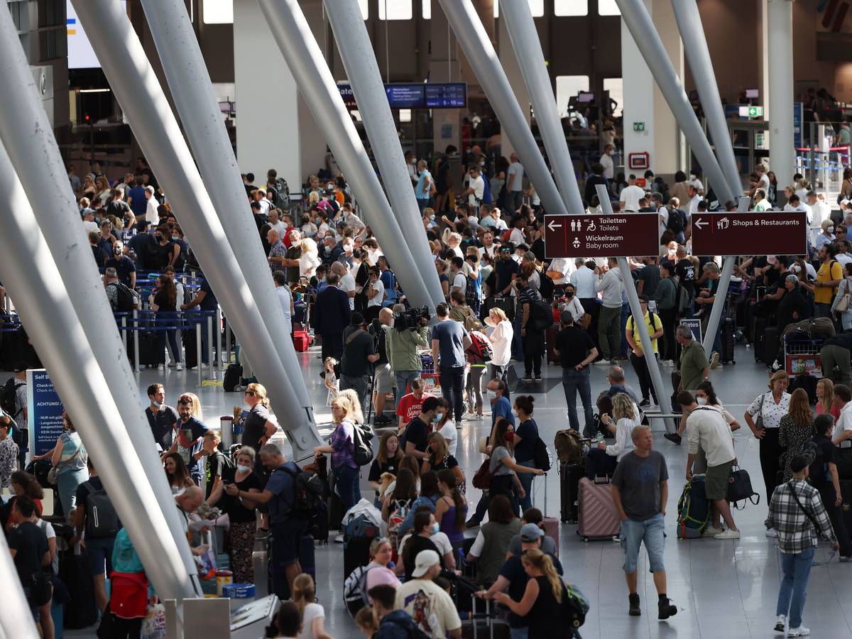 Passagiere stehen am 25. Juni 2022 im Flughafen Düsseldorf und warten auf ihre Abfertigungen.