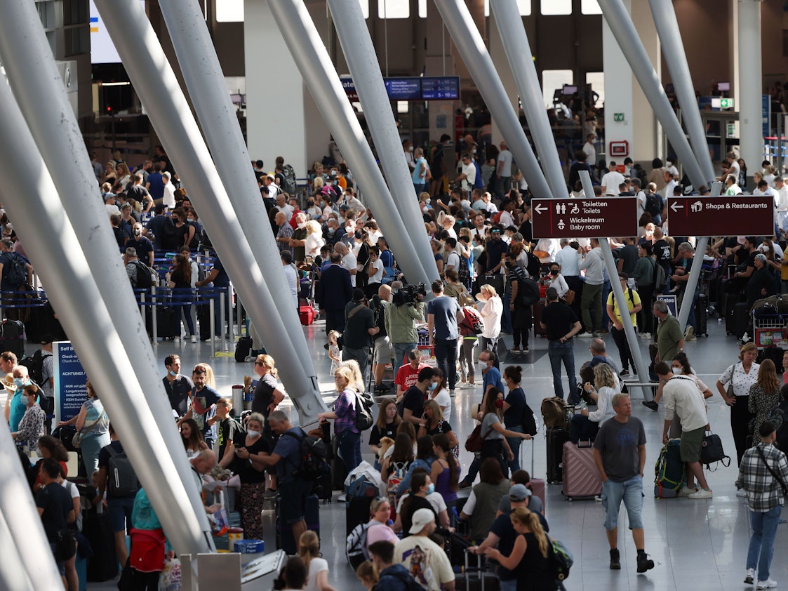 Passagiere stehen am 25. Juni 2022 im Flughafen Düsseldorf und warten auf ihre Abfertigungen.