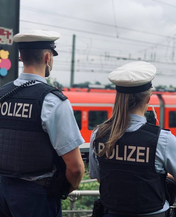 Das Foto zeigt eine Polizistin und einen Polizisten, die die Bahngleise beobachten.