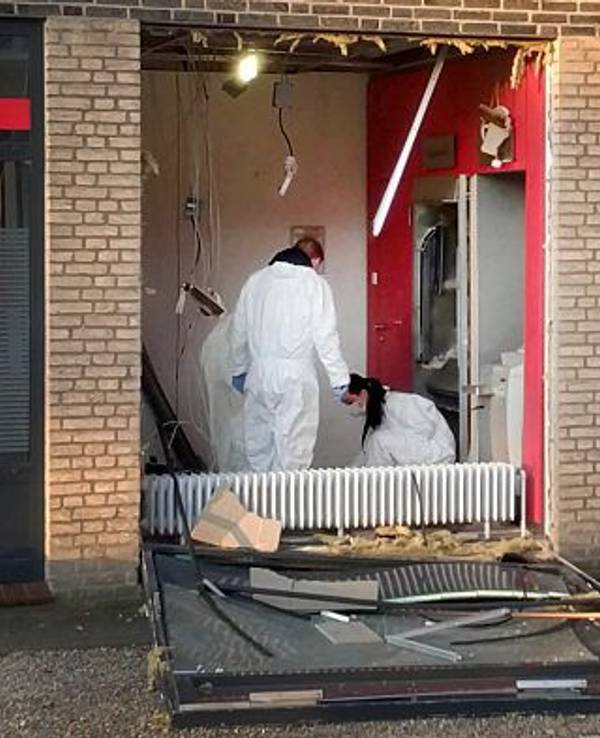 Eine Beamtin und ein Beamter in Schutzanzügen untersuchen den Tatort nach einer Geldautomatensprengung in NRW.