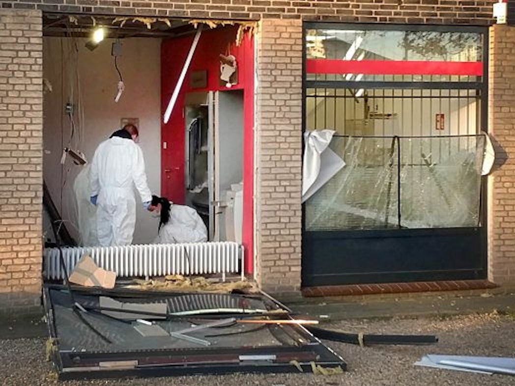 Eine Beamtin und ein Beamter in Schutzanzügen untersuchen den Tatort nach einer Geldautomatensprengung in NRW.