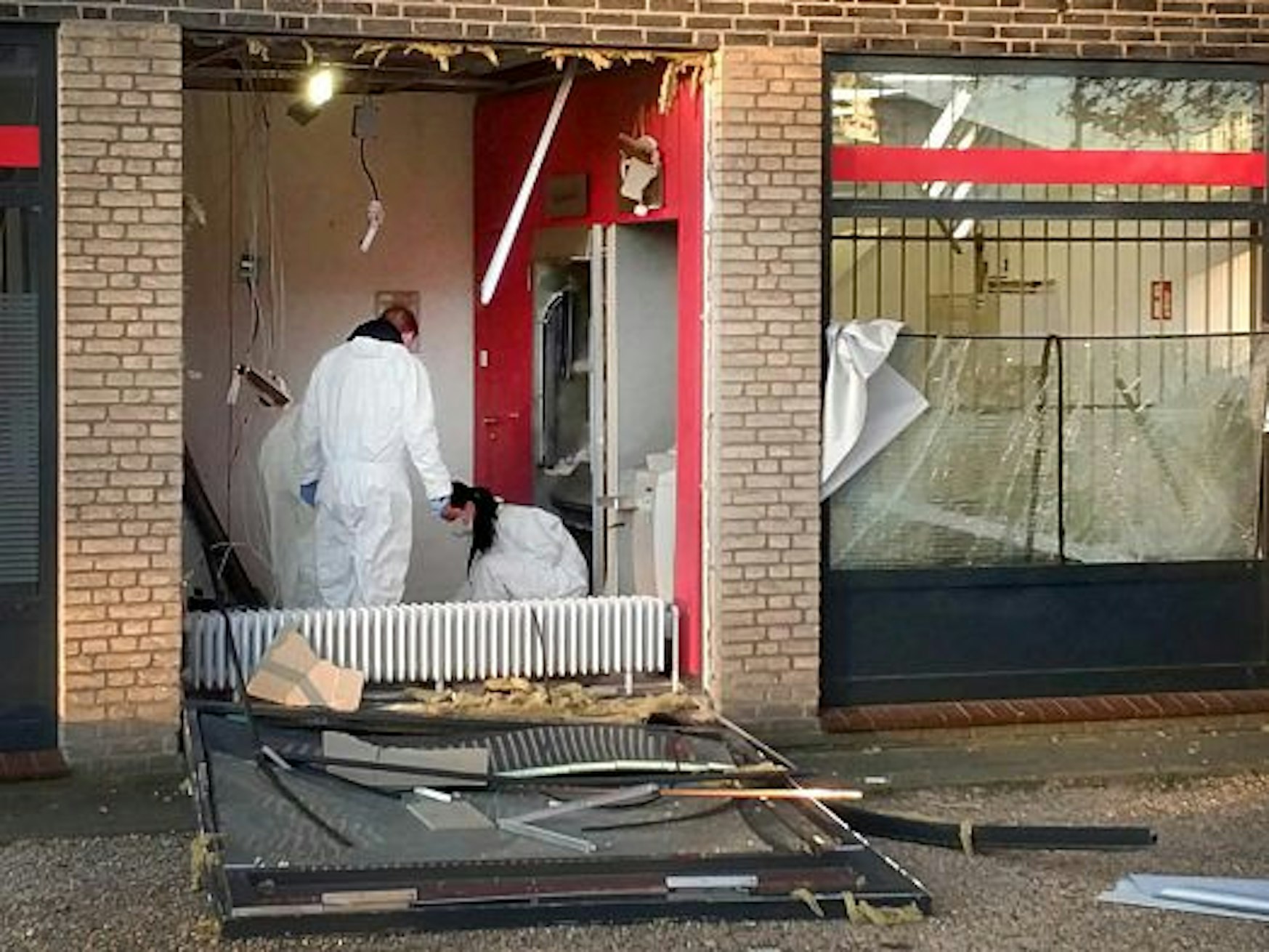 Eine Beamtin und ein Beamter in Schutzanzügen untersuchen den Tatort nach einer Geldautomatensprengung in NRW.
