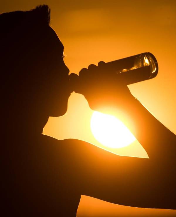 Eine spanische Biermarke hat sich eine besondere Aktion für alle Spanien-Urlaubenden ausgedacht, die unter dem Flug-Chaos leiden müssen. Das Symbolbild zeigt eine Person, die im Sonnenuntergang eine Flasche Bier trinkt.