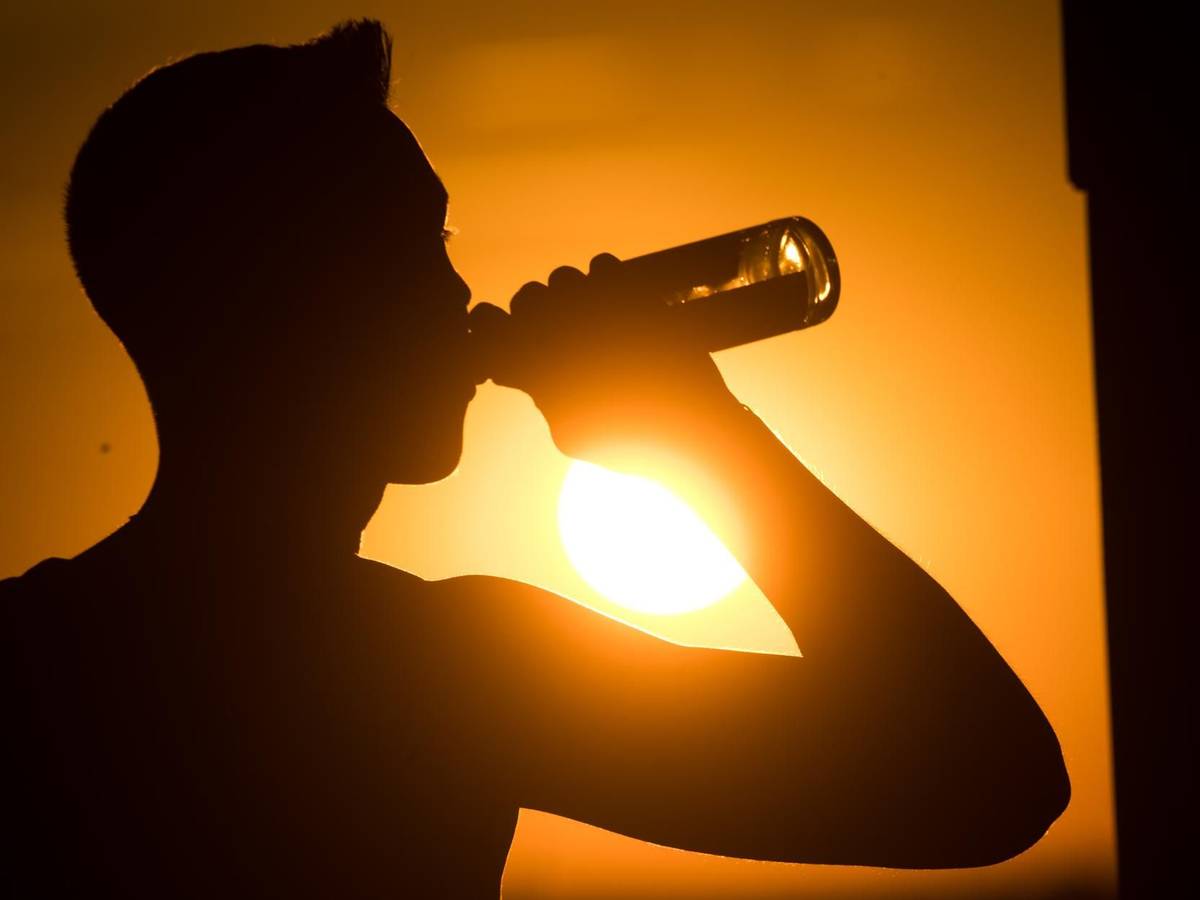 Eine spanische Biermarke hat sich eine besondere Aktion für alle Spanien-Urlaubenden ausgedacht, die unter dem Flug-Chaos leiden müssen. Das Symbolbild zeigt eine Person, die im Sonnenuntergang eine Flasche Bier trinkt.