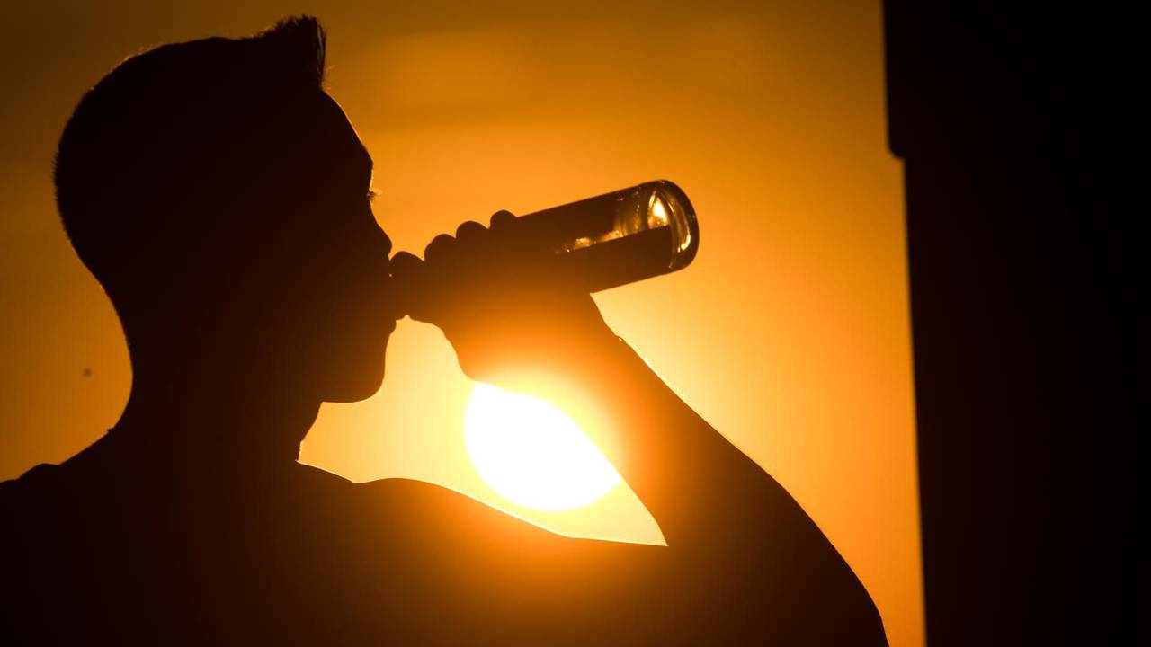 Eine spanische Biermarke hat sich eine besondere Aktion für alle Spanien-Urlaubenden ausgedacht, die unter dem Flug-Chaos leiden müssen. Das Symbolbild zeigt eine Person, die im Sonnenuntergang eine Flasche Bier trinkt.