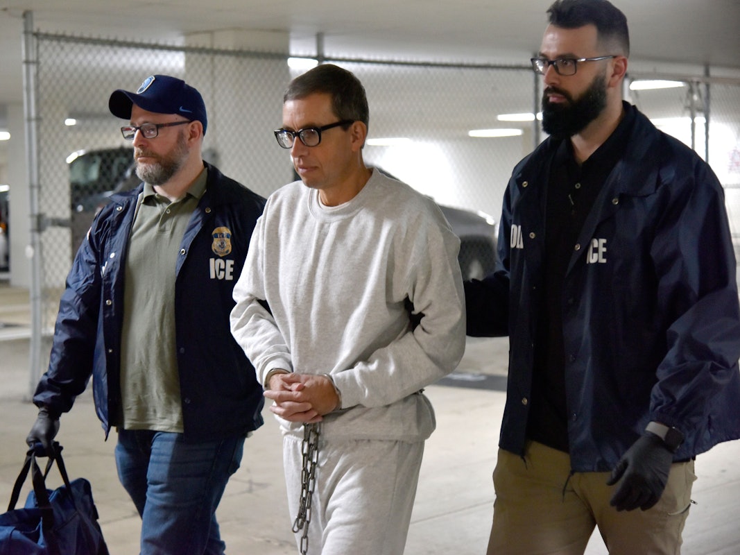 Jens Söring wird in den USA mit Handschellen von zwei Beamten zu einem Auto begleitet. Söring darf die USA verlassen und wird nach Deutschland abgeschoben.