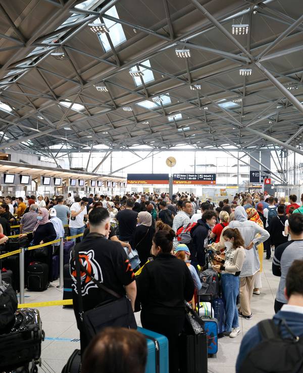 Passagiere stehen in einer Schlange von mehreren hundert Metern für die Sicherheitskontrolle am Flughafen Köln-Bonn an.
