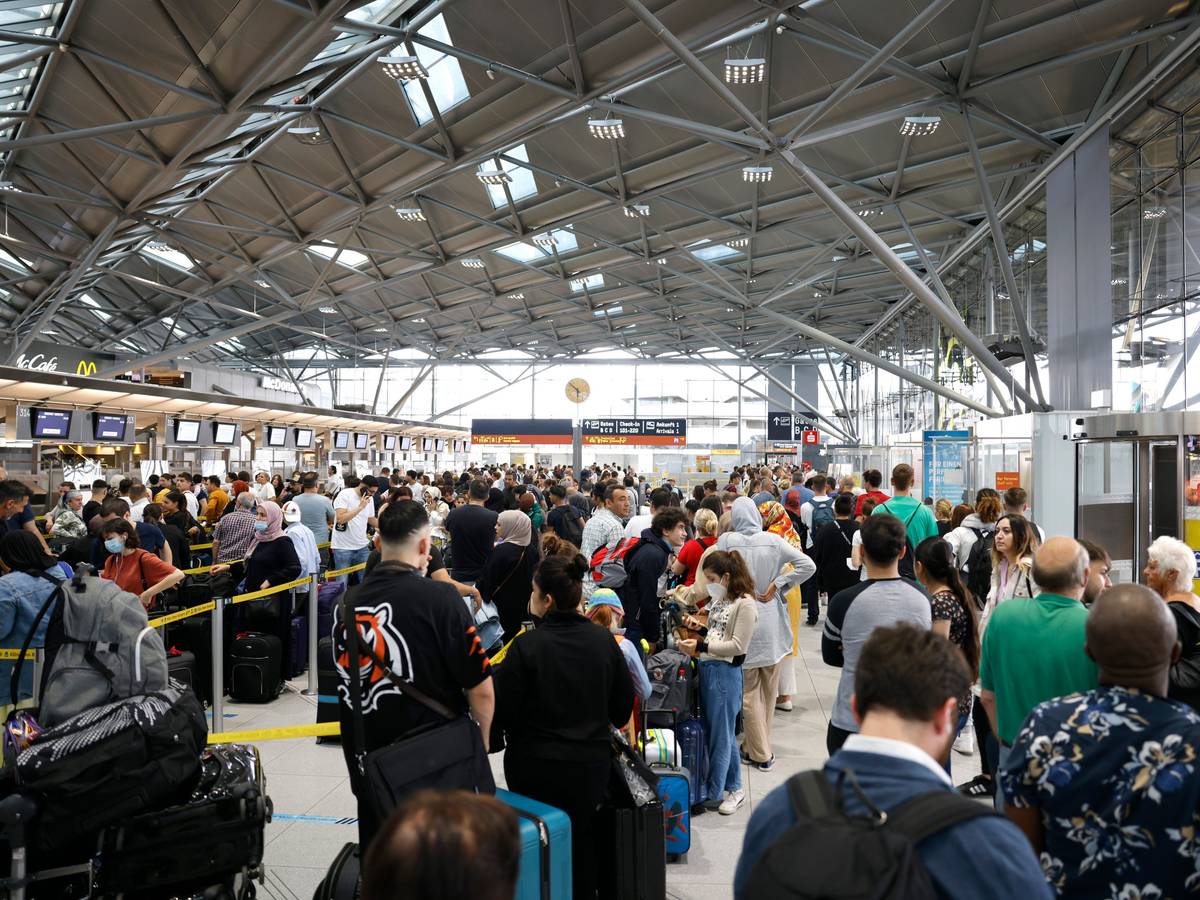 Reisende stehen am 24. Juni 2022 in einer Schlange von mehreren hundert Metern für die Sicherheitskontrolle am Flughafen Köln-Bonn an.