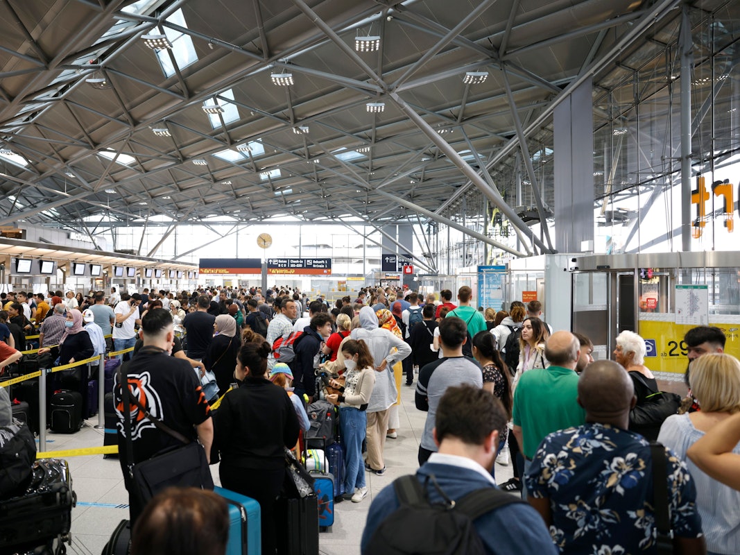 Reisende stehen am 24. Juni 2022 in einer Schlange von mehreren hundert Metern für die Sicherheitskontrolle am Flughafen Köln-Bonn an.