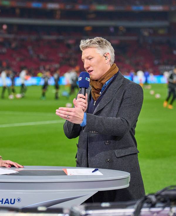 Esther Sedlaczek und Bastian Schweinsteiger im Gespräch am Spielfeldrand.
