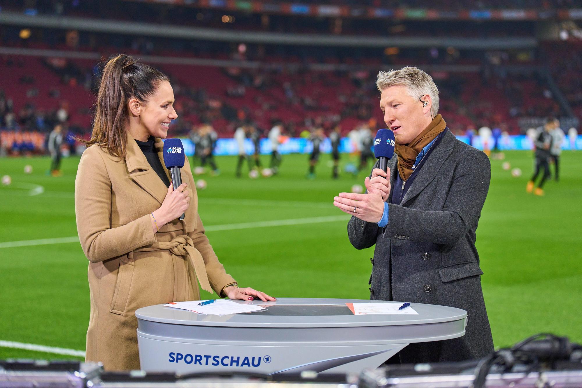 Esther Sedlaczek und Bastian Schweinsteiger im Gespräch am Spielfeldrand.