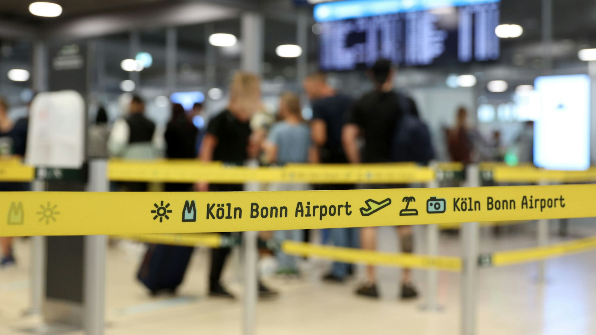 Reisende warten an der Sicherheitskontrolle des Flughafens.