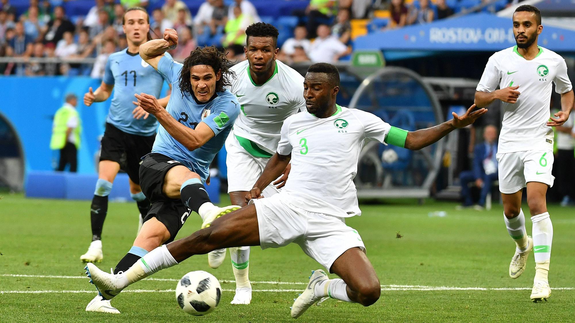 Uruguays Cavani schießt aufs Tor, Saudi-Arabiens Verteidiger Hawsawi versucht den Ball zu blocken.