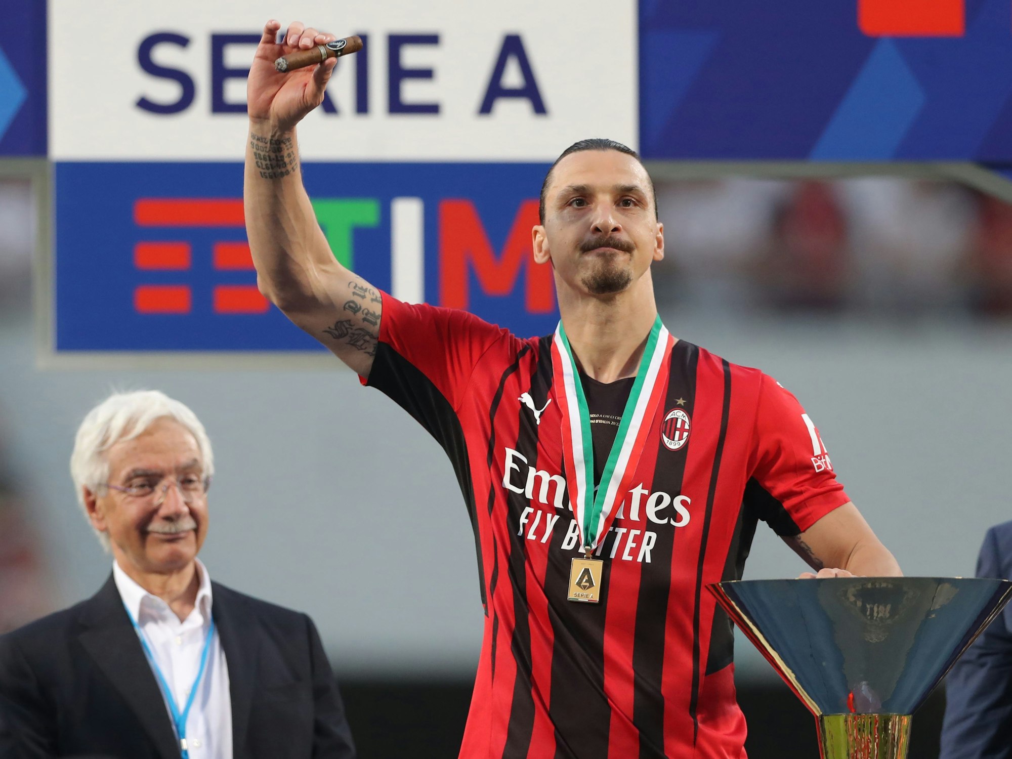 Zlatan Ibrahimovic zelebriert mit Zigarre und Hand an der Trophäe den Serie-A-Titel 2022.