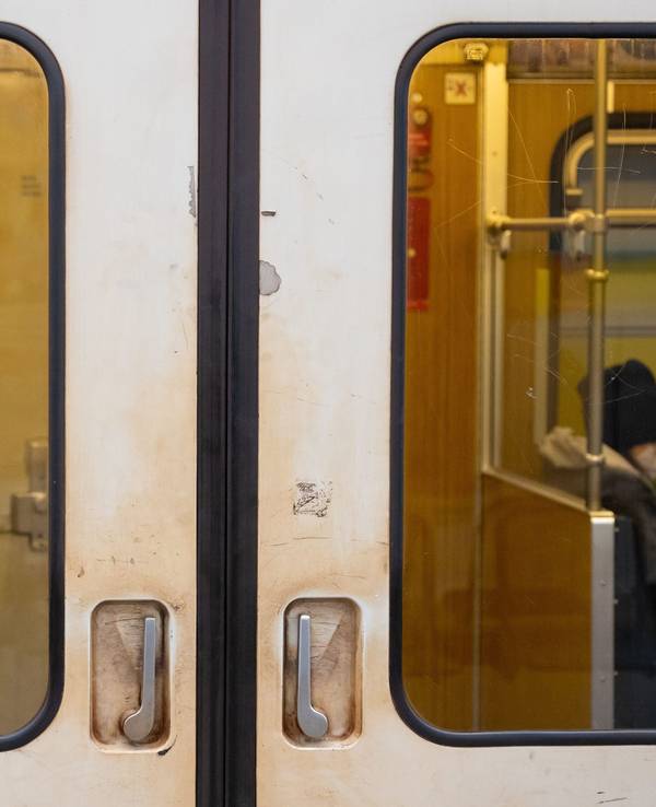 Ein Aufkleber mit der Aufschrift „Mund und Nase bedecken!“ ist an einer U-Bahn angebracht.