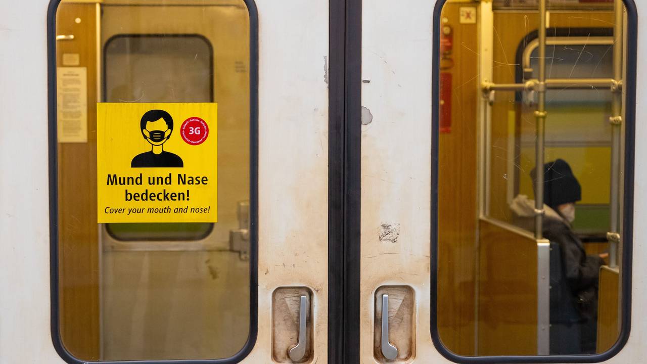 Ein Aufkleber mit der Aufschrift „Mund und Nase bedecken!“ ist an einer U-Bahn angebracht.