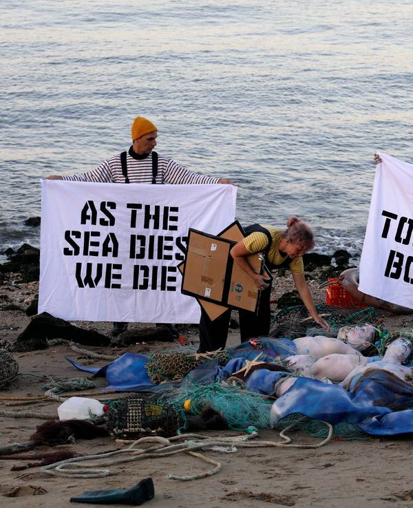 Aktivisten der Ocean Rebellion veranstalten am Ufer des Tejo eine Performance, bei der sie ein Ende aller nationalen Treibstoffsubventionen für Fischereiflotten und ein Verbot der Grundschleppnetzfischerei fordern.