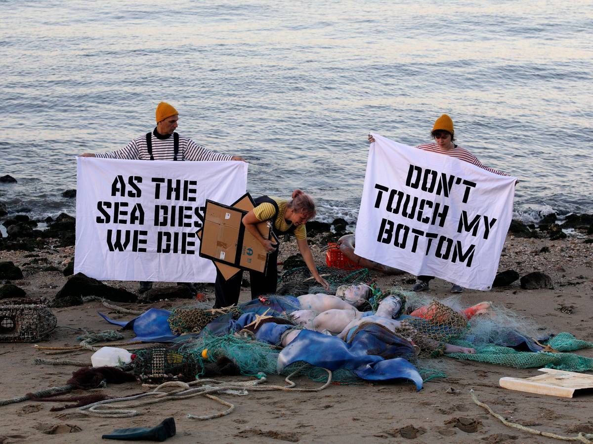 Aktivisten der Ocean Rebellion veranstalten am Ufer des Tejo eine Performance, bei der sie ein Ende aller nationalen Treibstoffsubventionen für Fischereiflotten und ein Verbot der Grundschleppnetzfischerei fordern.