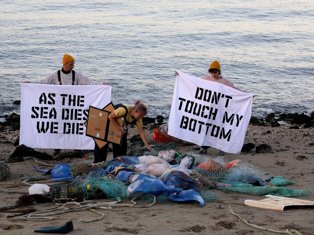 Aktivisten der Ocean Rebellion veranstalten am Ufer des Tejo eine Performance, bei der sie ein Ende aller nationalen Treibstoffsubventionen für Fischereiflotten und ein Verbot der Grundschleppnetzfischerei fordern.