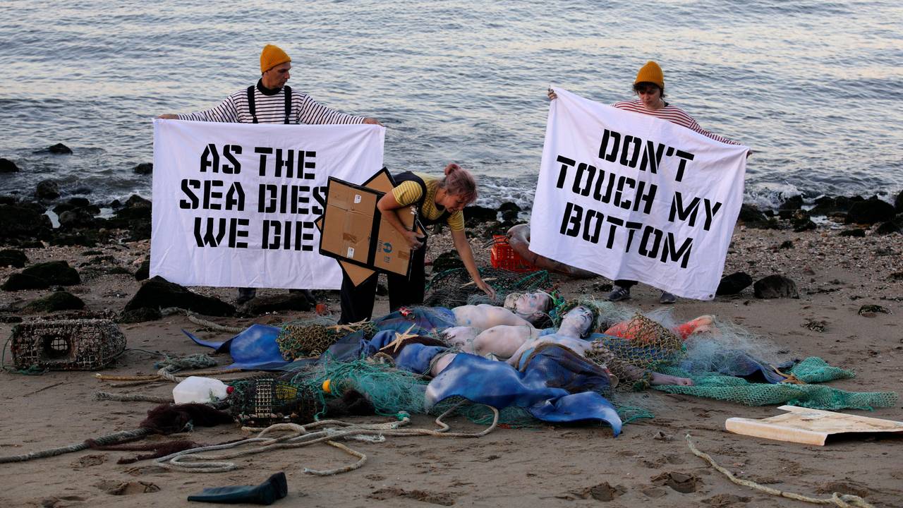 Aktivisten der Ocean Rebellion veranstalten am Ufer des Tejo eine Performance, bei der sie ein Ende aller nationalen Treibstoffsubventionen für Fischereiflotten und ein Verbot der Grundschleppnetzfischerei fordern.
