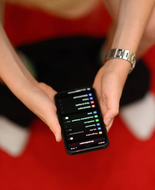 30.06.2022, Sachsen, Dresden: Eine Junge hält auf der Toilette sein Smartphone in den Händen. Immer mehr Deutsche nehmen ihr Smartphone mit auf die Toilette.